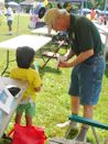 Ned Stone helps a young visitor make a paper bird.